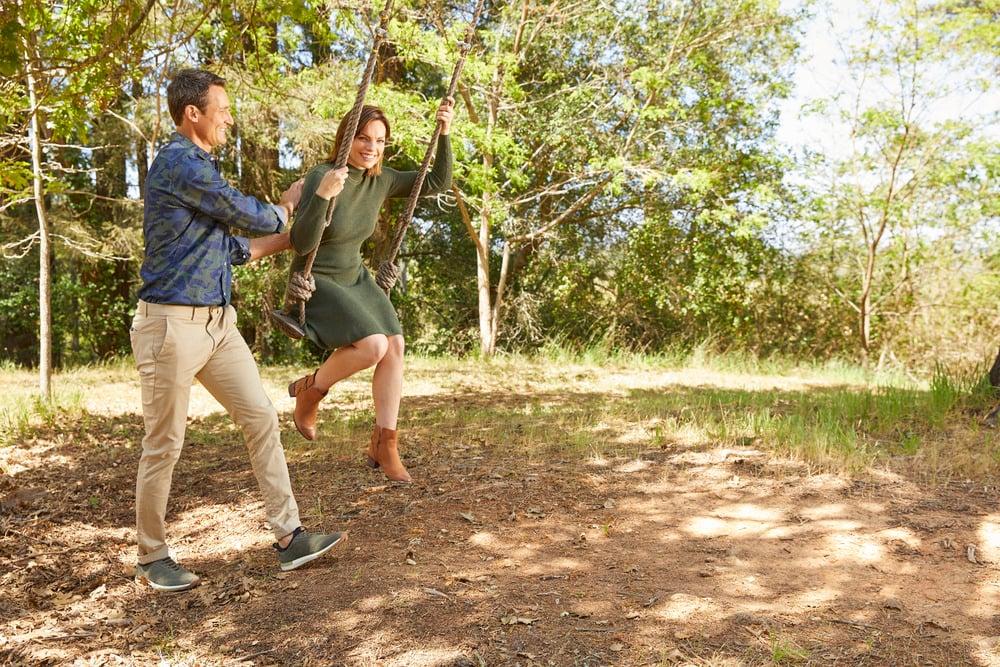 Man and woman having fun outdoor, wearing fall outfits with boots