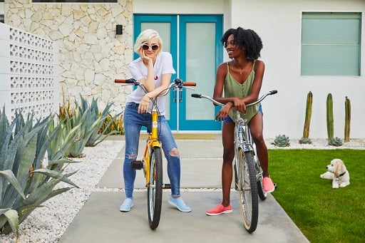 Two woman wearing sneakers ready to go for a bike ride