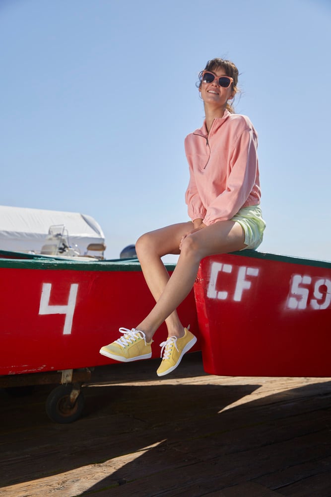 oung woman in sporty outfit sitting on a boat