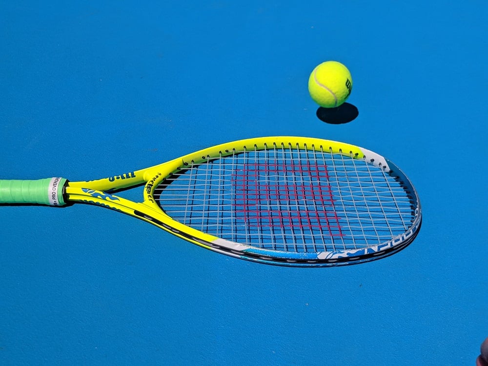 Tennis racket and ball on a blue background