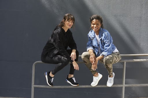 Two young women in sporty outfits with sneakers