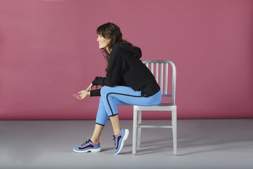 woman in sporty outfit, sitting on a chair