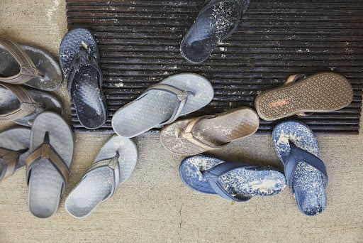 bunch of sandals on a sandy beach